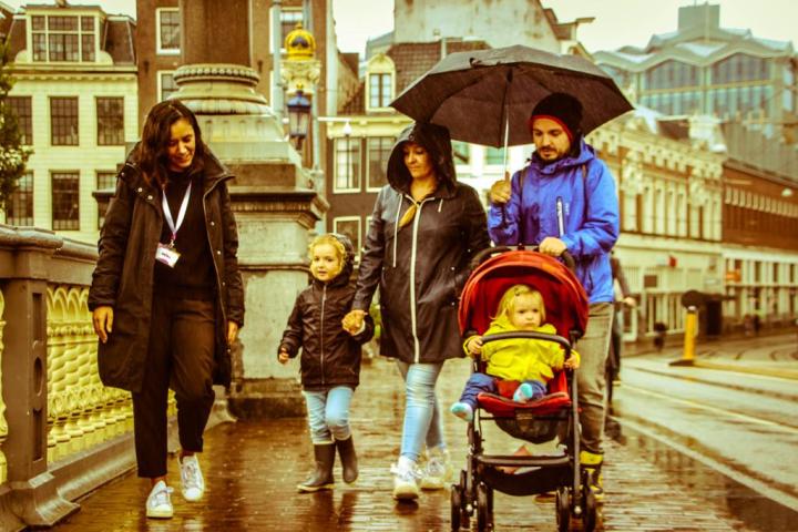 a group of people walking down a street holding an umbrella